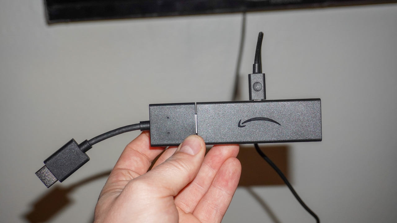 Image of a person holding an Amazon Firestick device